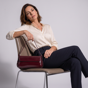 Modelo sentada con el bolso de piel genuina Camille