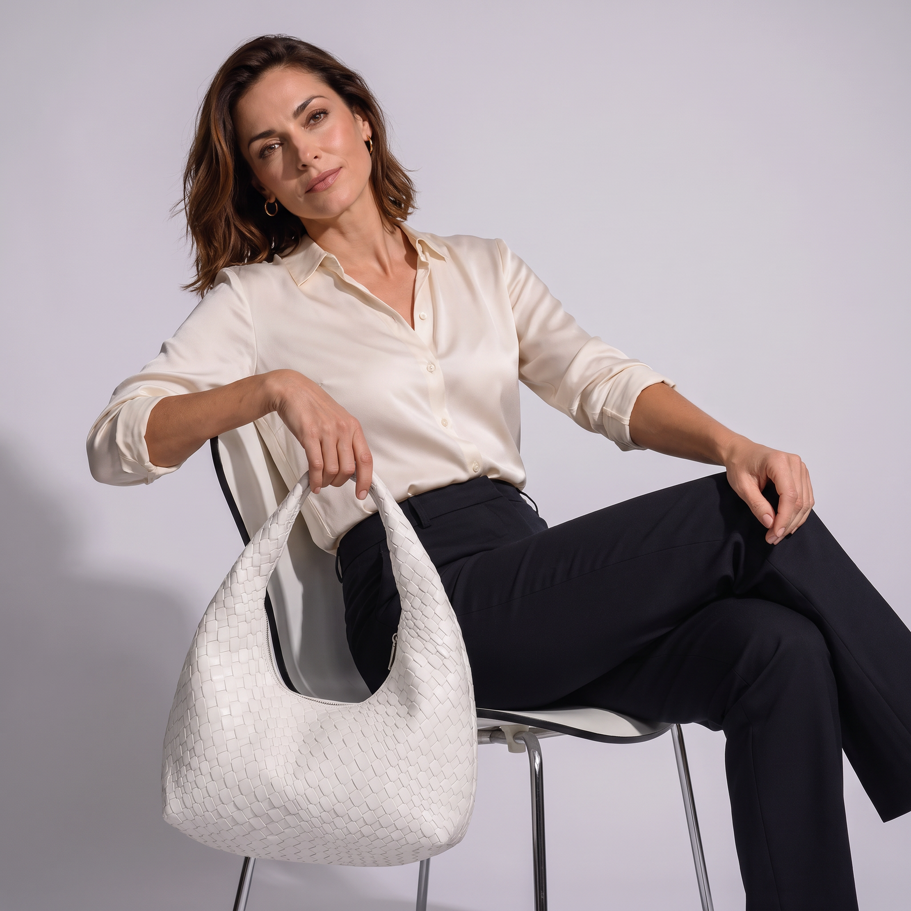 Modelo sentada con el bolso de piel genuina Grace
