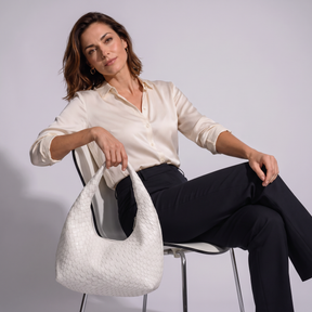 Modelo sentada con el bolso de piel genuina Grace